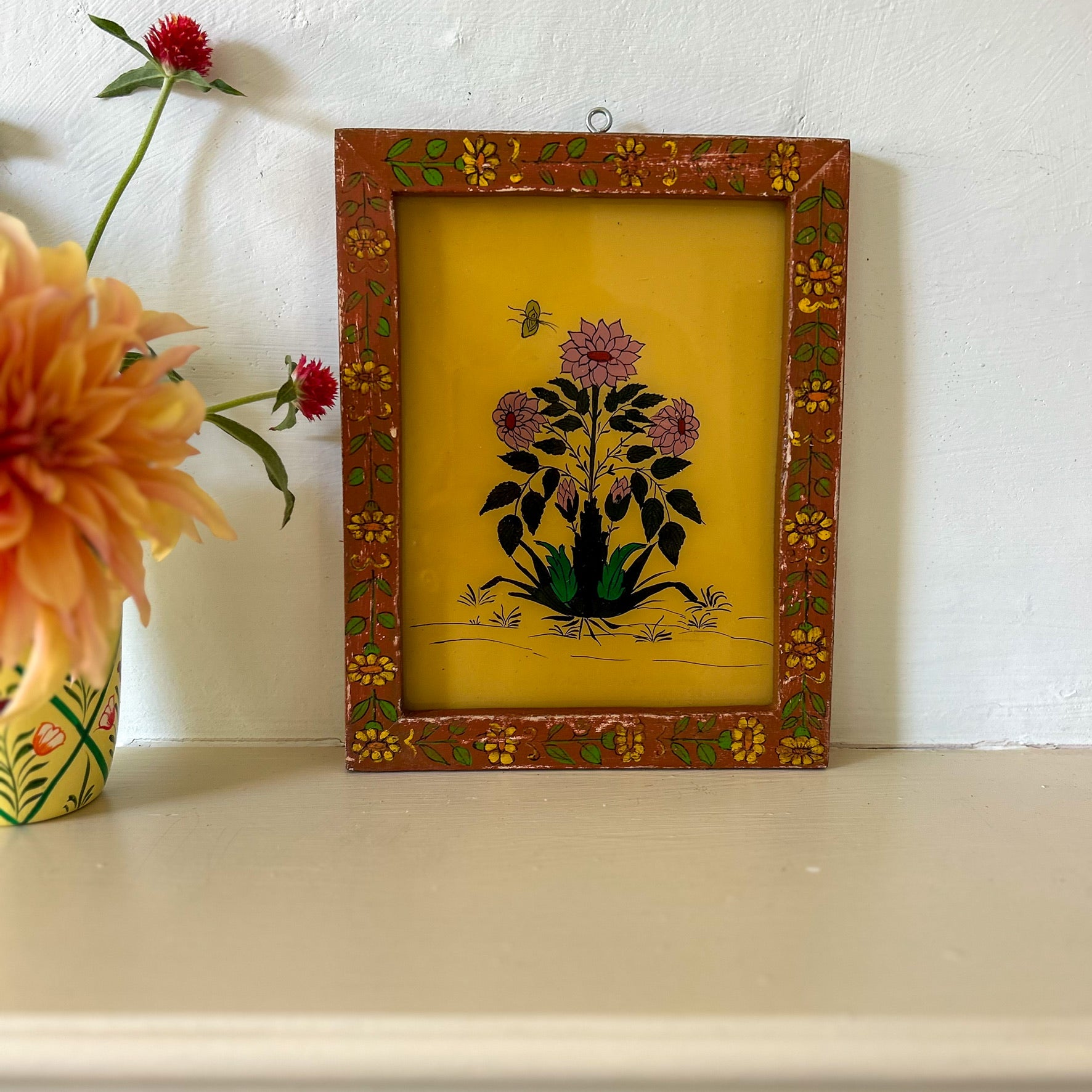 Decorative framed artwork with floral design on a white surface. constance-and-denny-indian-reverse-glass-painting-boxed-packaging-hand-painted-artisan-art-dahlia