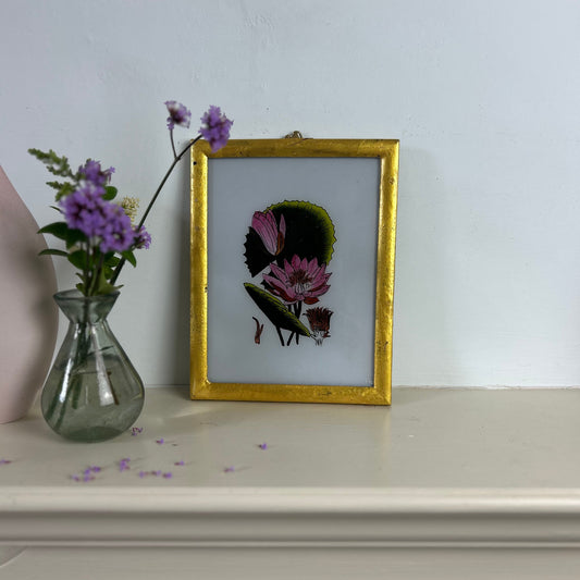 Framed artwork with flowers on a white surface. indian-glass-painting-reverse-art-flower-pink