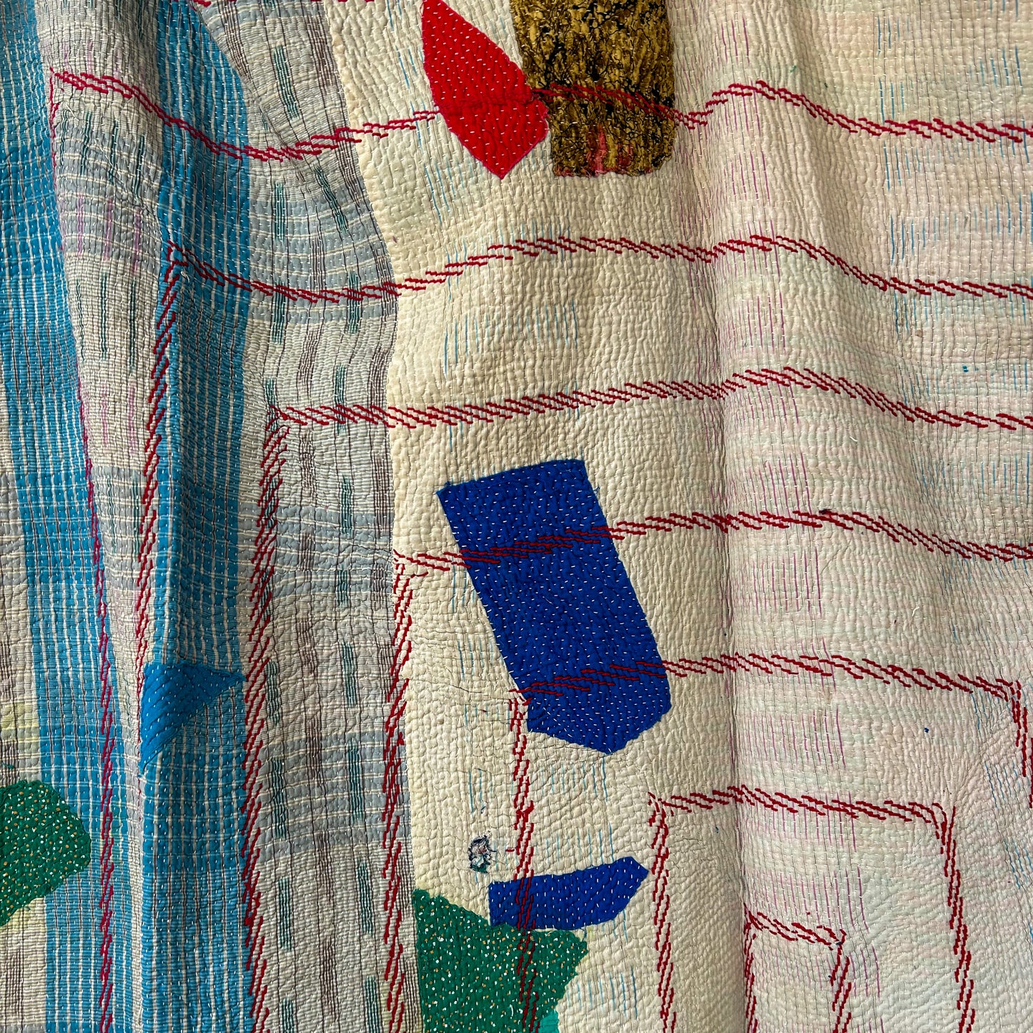 Close-up of a textured fabric with embroidered patterns and colors. kantha-vintage-2027 - hand-made-blanket-throw-textiles-wall-hanging