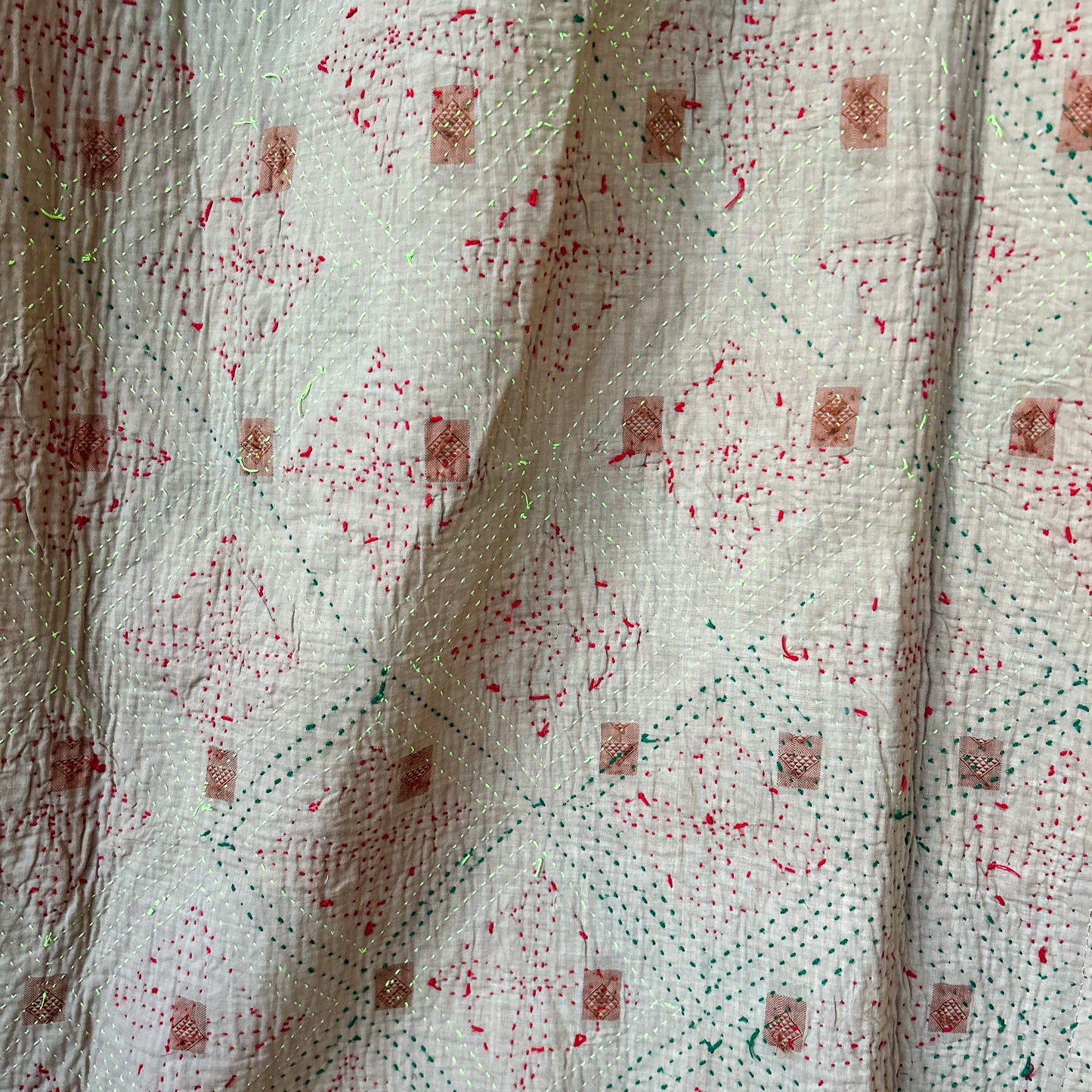 Textured kantha with red and green speckles on a white background