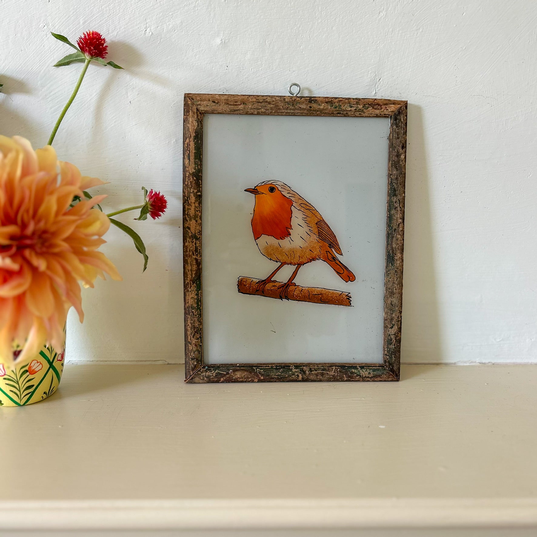 Framed artwork of a robin on a white surface with flowers. constance-and-denny-indian-reverse-glass-painting-boxed-packaging-hand-painted-artisan-art-robin-red