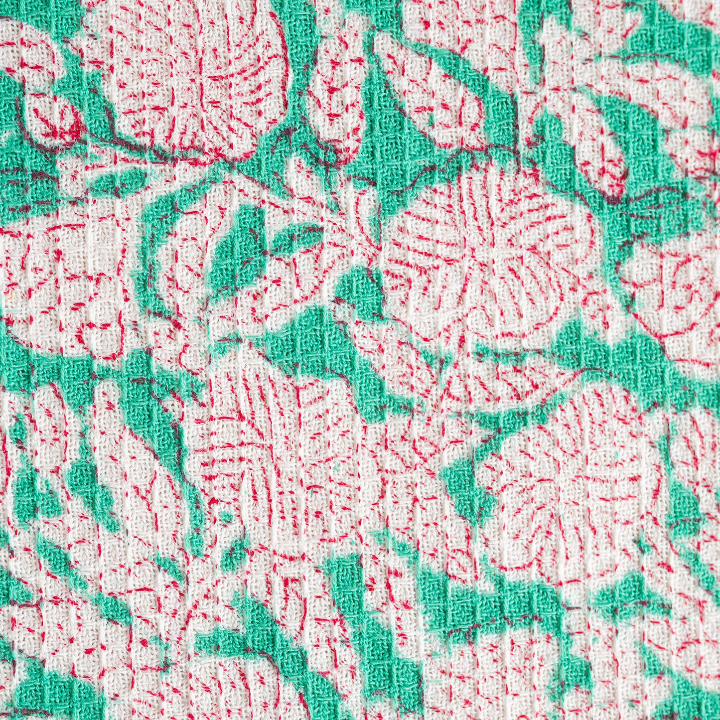 Close-up of a floral patterned fabric with red and green colors.