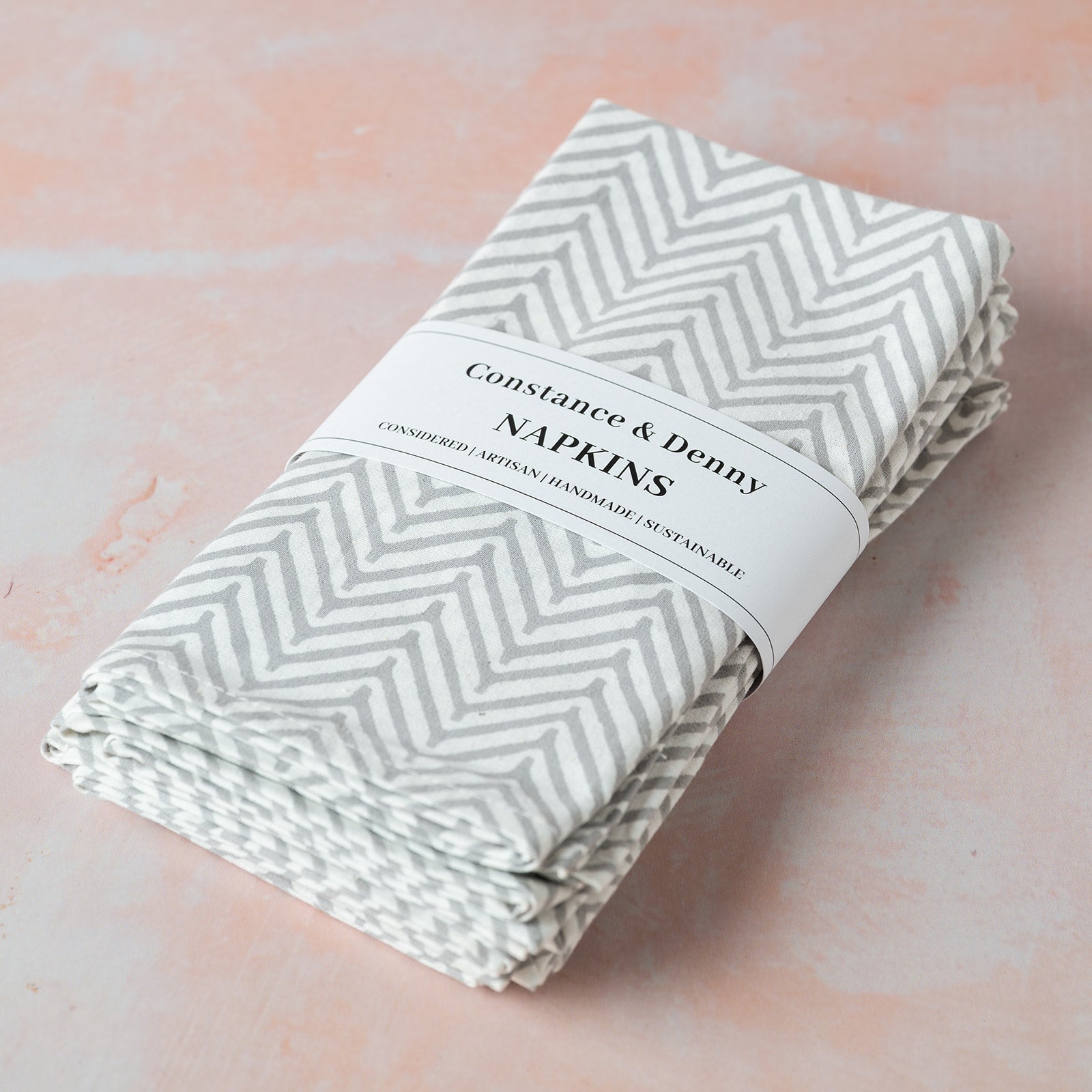 Folded napkins with a chevron pattern on a pink background