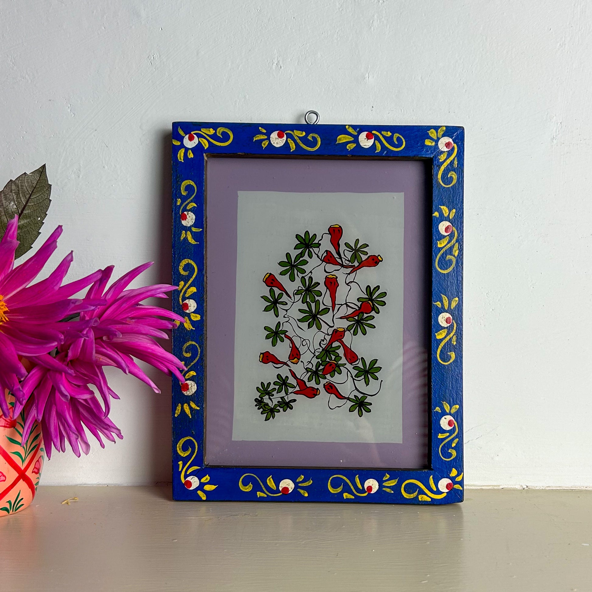 Decorative framed artwork with floral design on a white wall