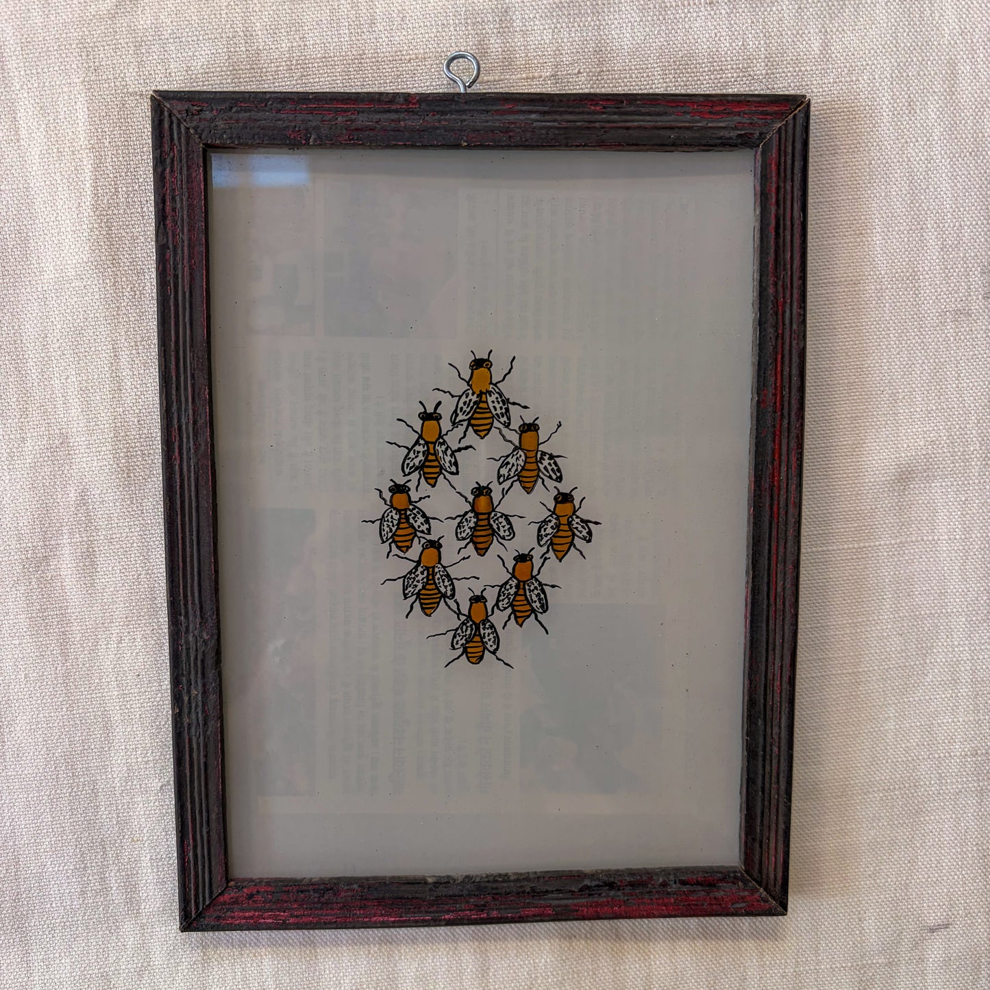 Framed artwork of bees on a textured wall