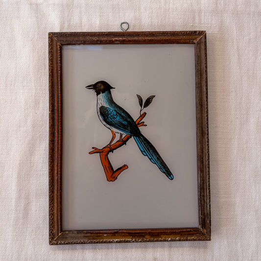 Framed artwork of a bird on a branch with a textured beige background