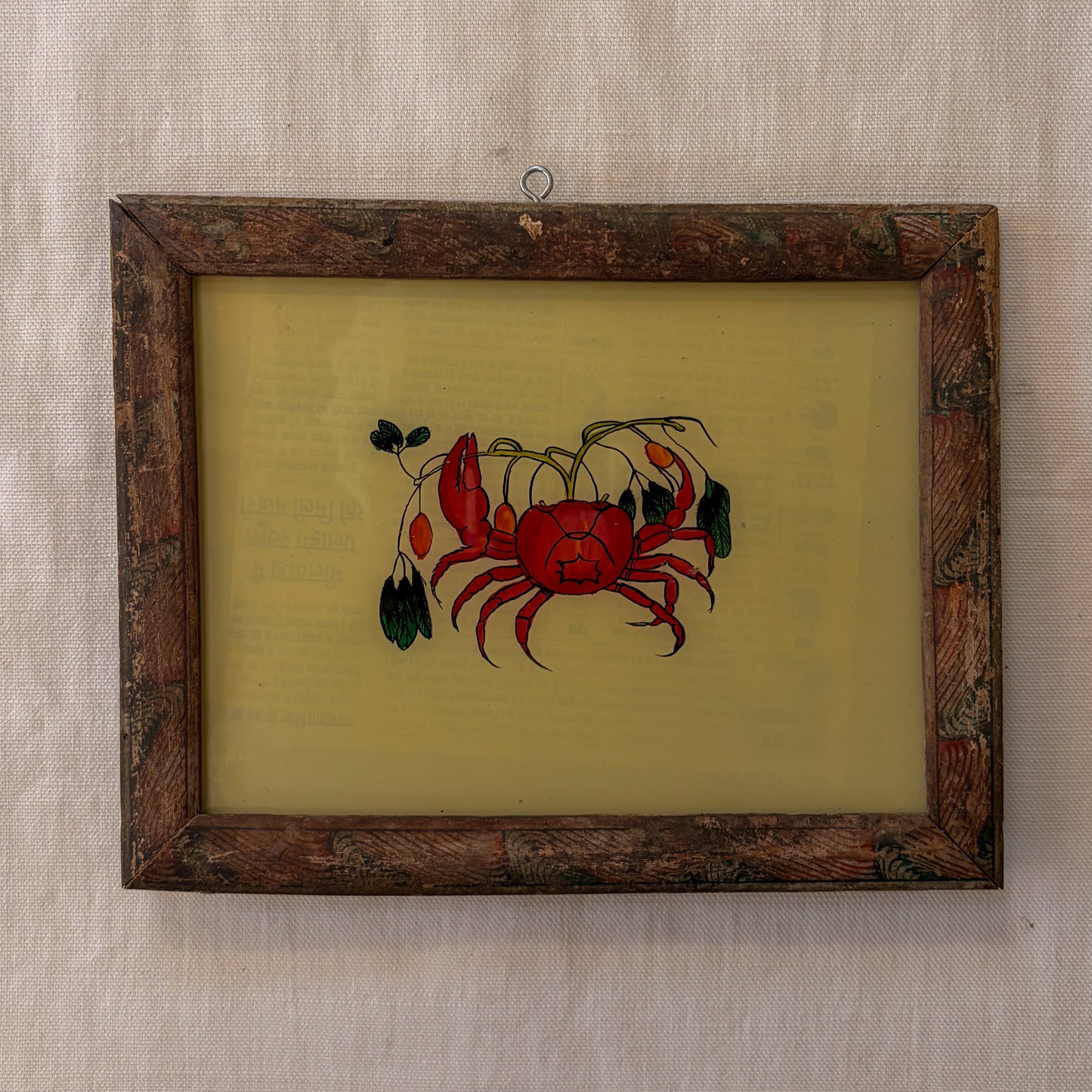 Framed artwork of a red crab on a beige background