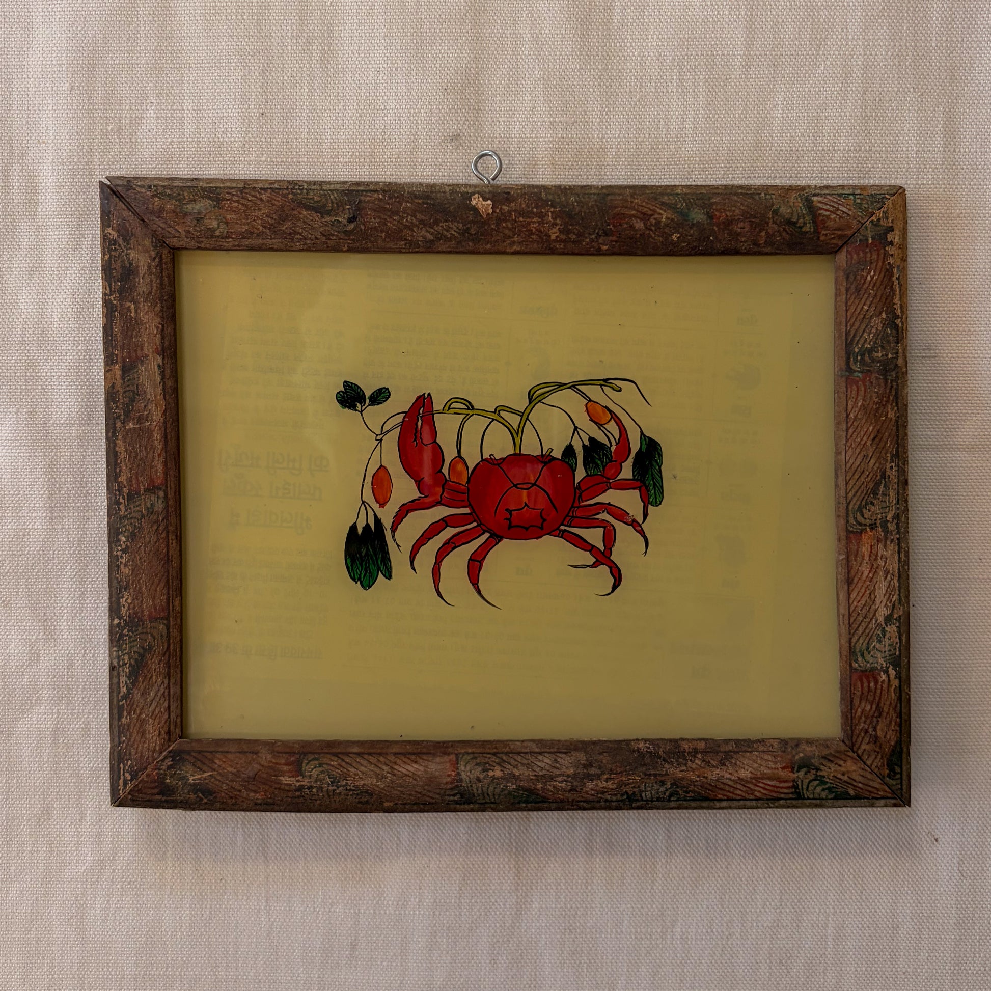 Framed artwork of a red crab on a beige background
