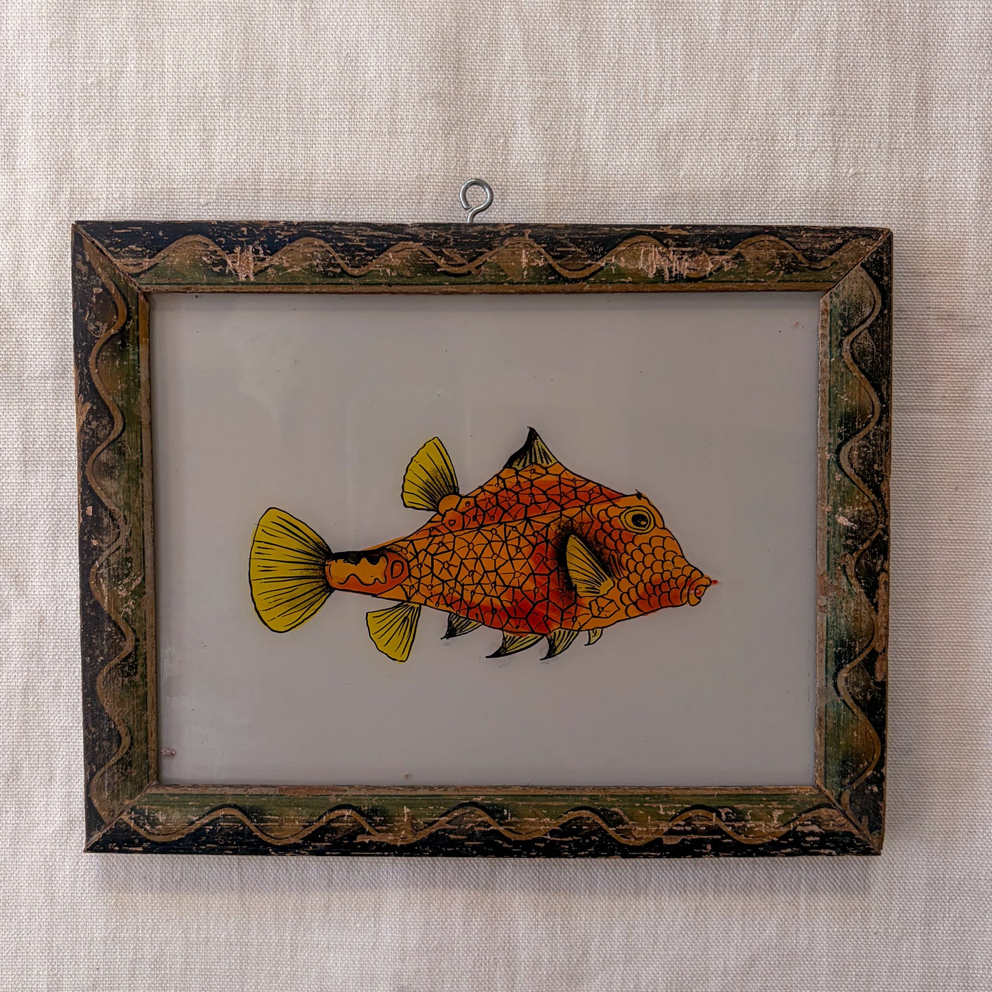 Framed artwork of a fish on a textured beige background