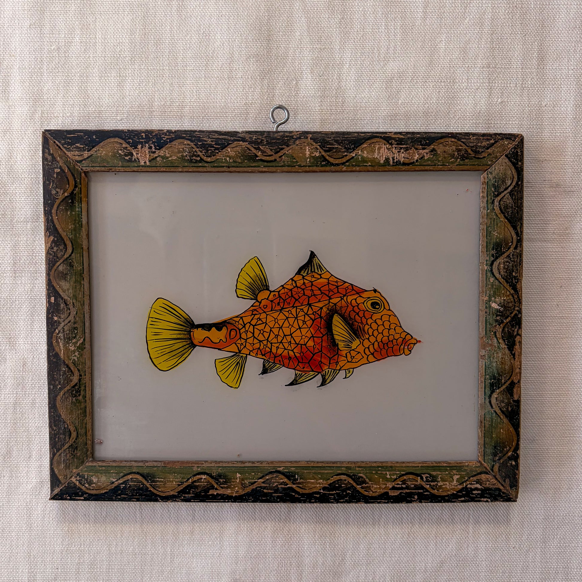 Framed artwork of a fish on a textured beige background