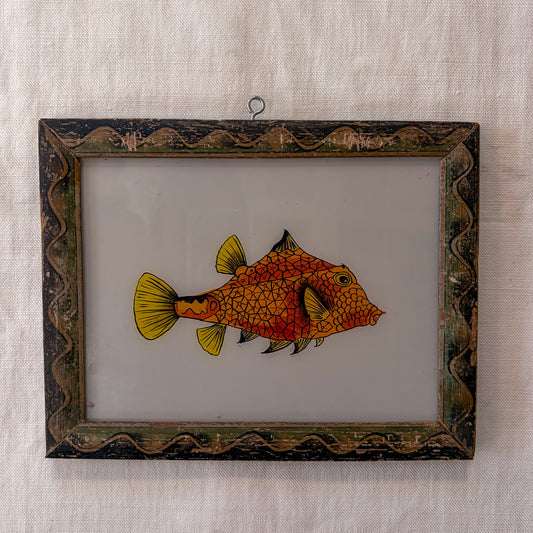 Framed artwork of a fish on a textured beige background