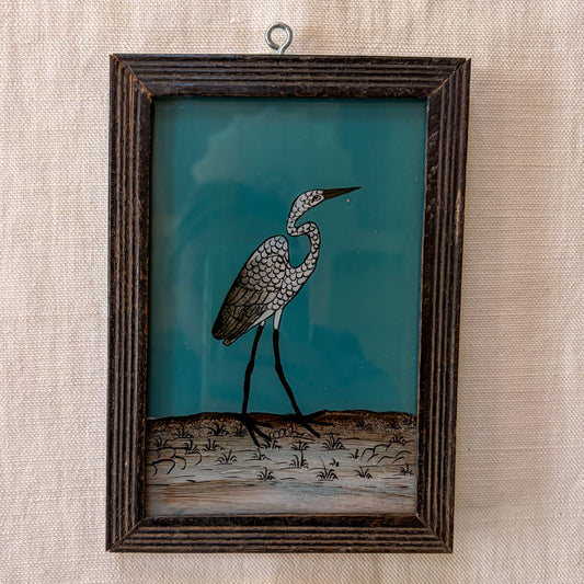 Framed artwork of a heron on a textured wall