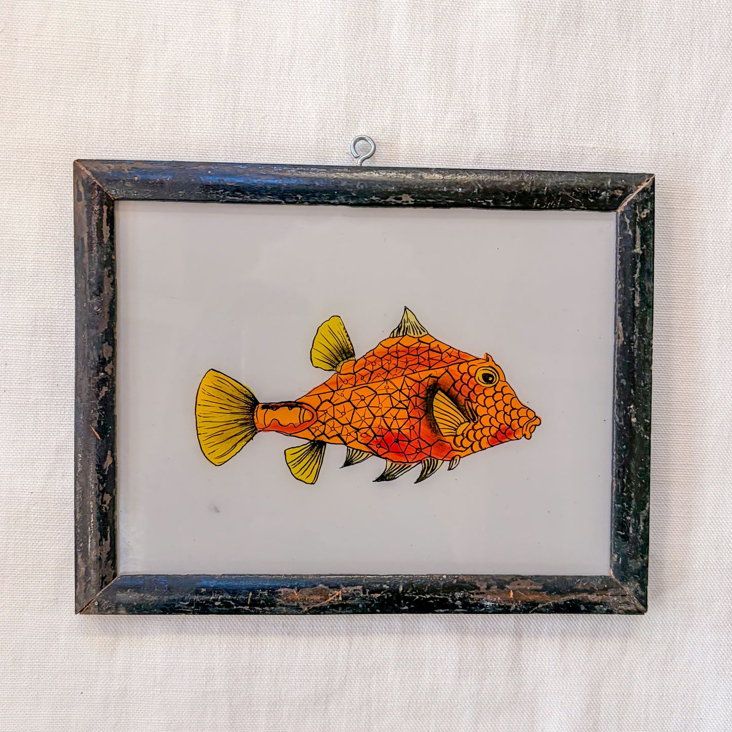 Framed artwork of a colorful fish on a textured white background