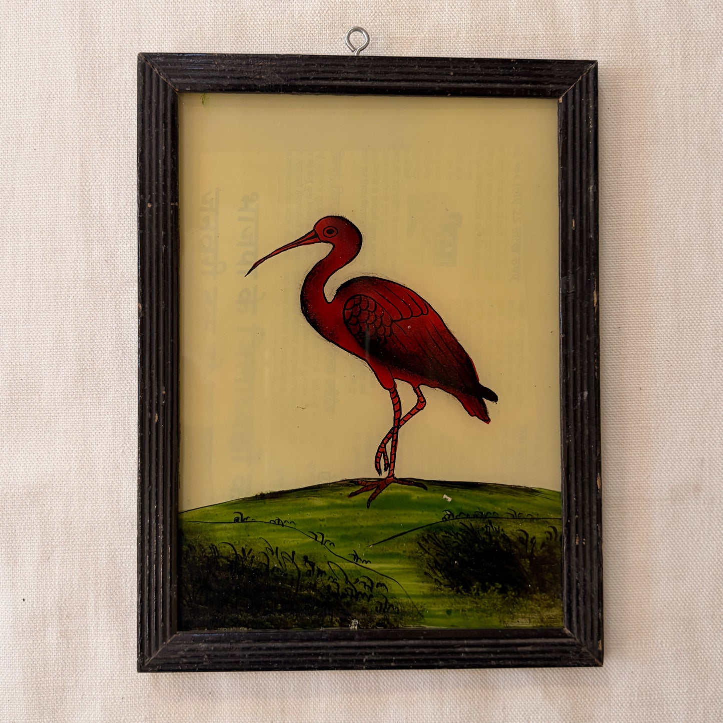Framed artwork of a red ibis bird on a beige background
