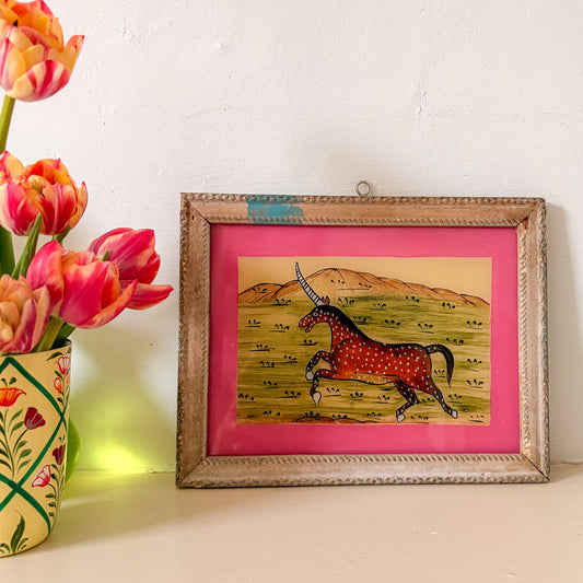 Framed artwork of a spotted horse on a pink background with tulips beside it.