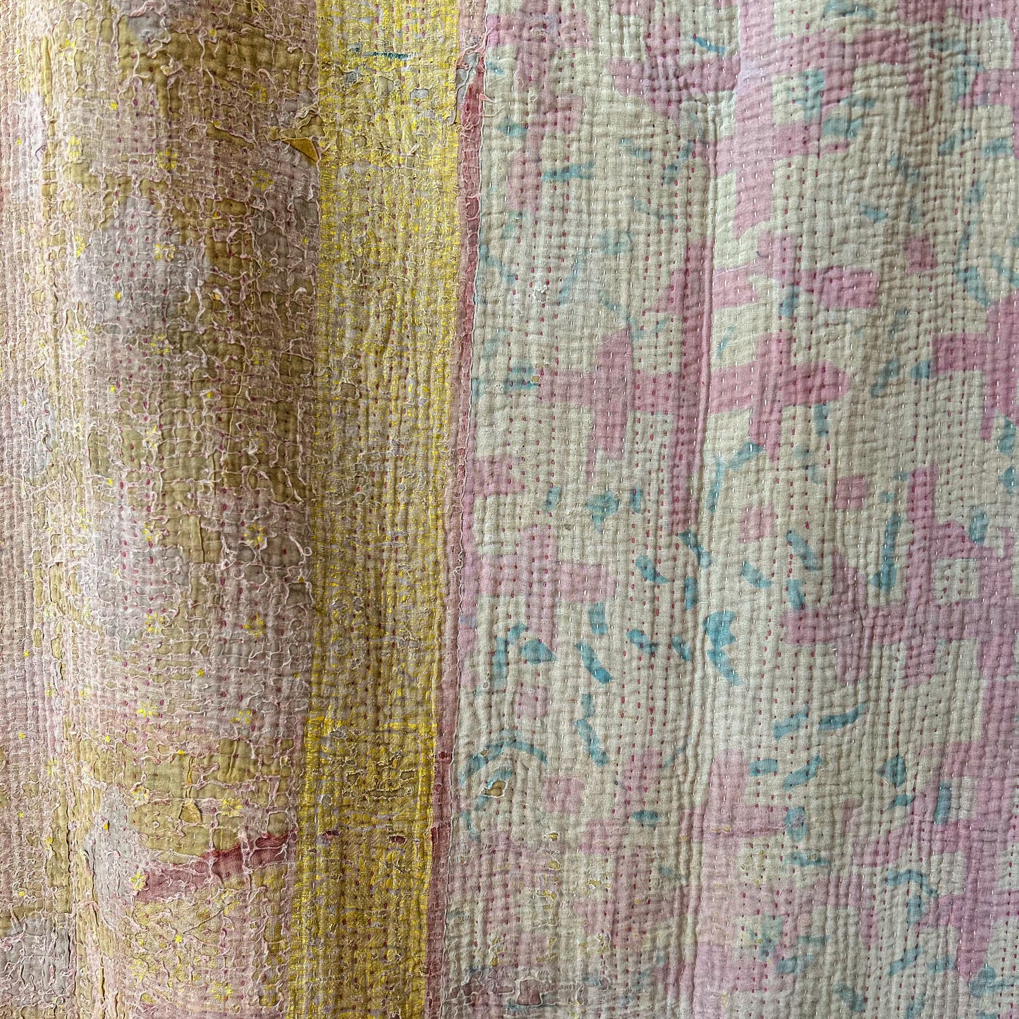 Close-up of a textured fabric with a floral pattern in pink and green.Vintage-kantha-2019-A-blanket-throw