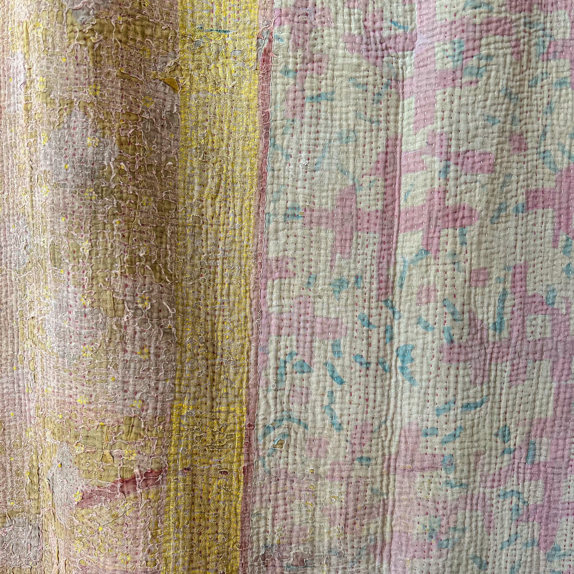 Close-up of a textured fabric with a floral pattern in pink and green.Vintage-kantha-2019-A-blanket-throw