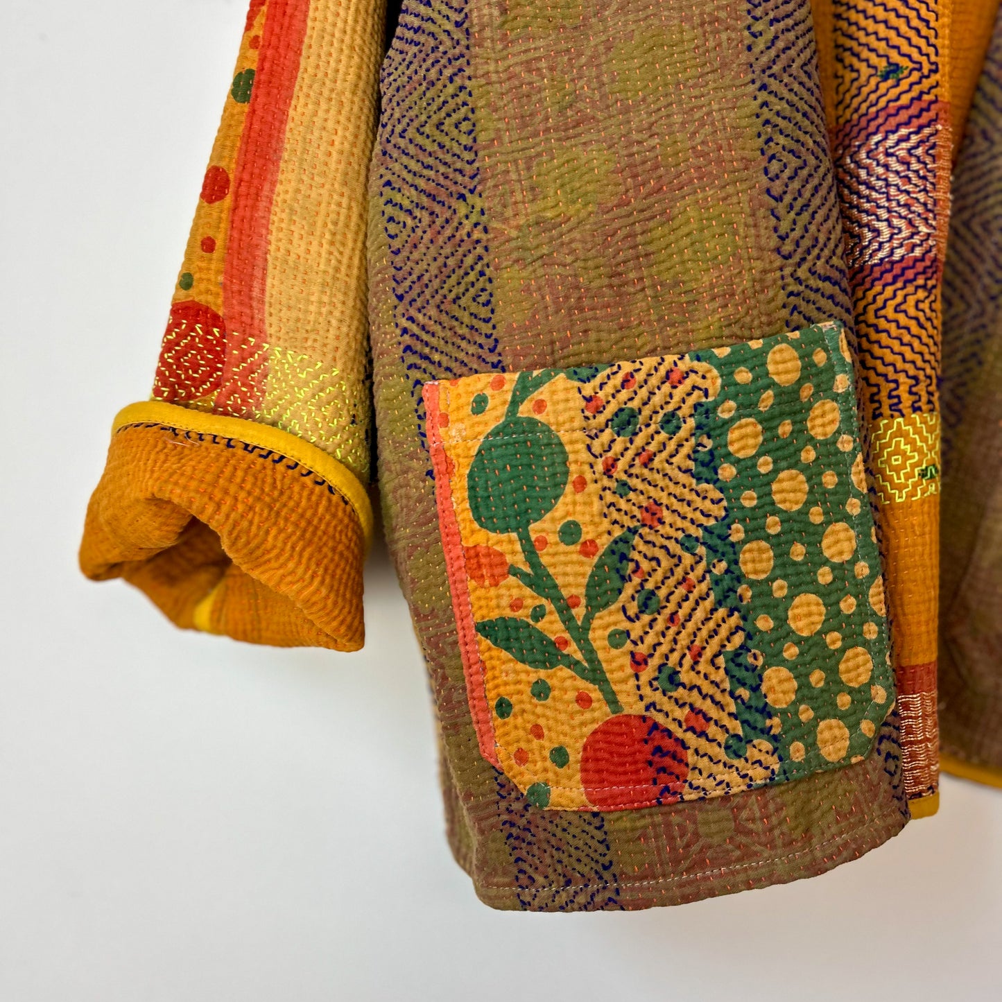 Colorful fabric with a floral pattern on a white background. Vintage-kantha-jacket-handmade-unique-35-orange-stitching