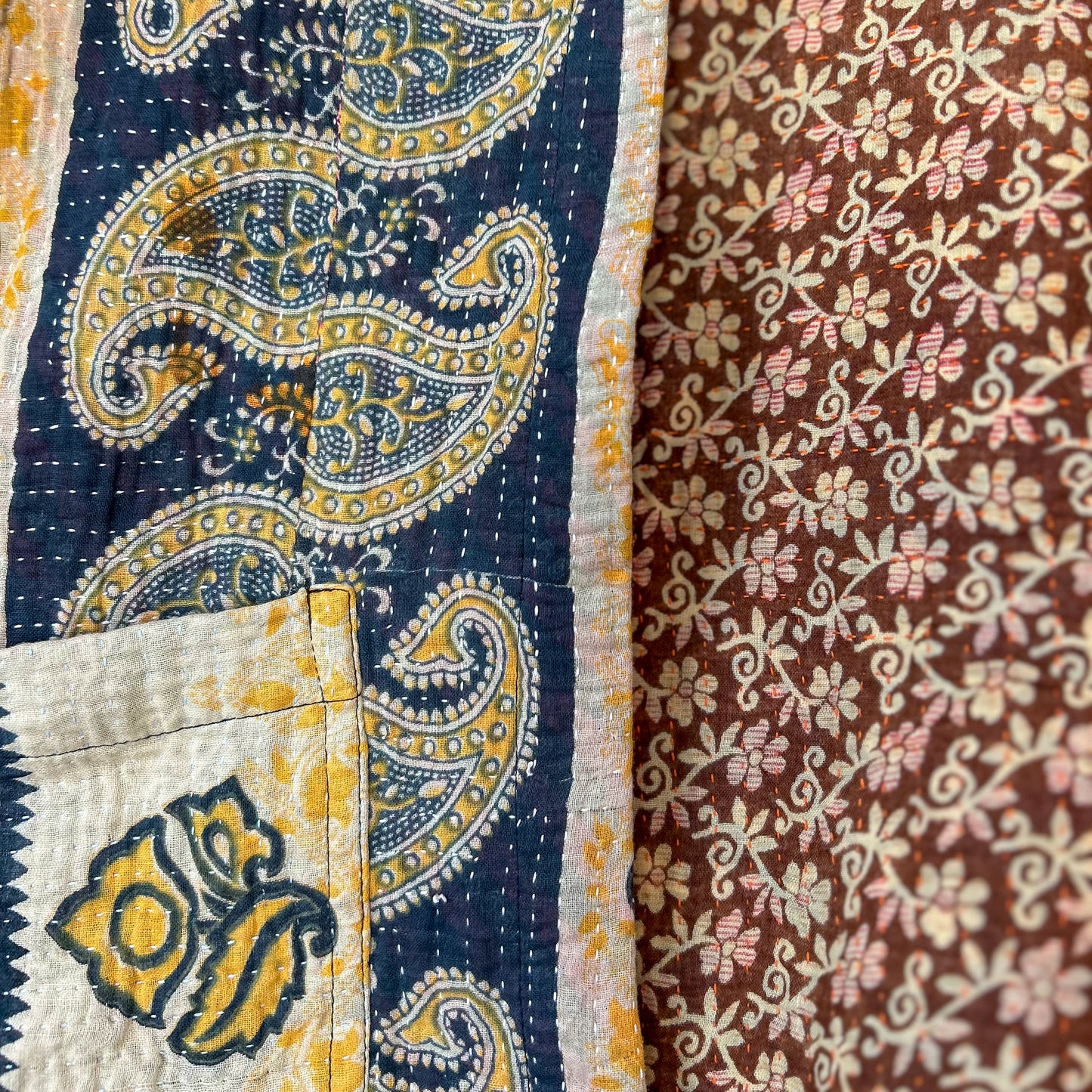 Close-up of a patchwork quilt with paisley and floral patterns.Vintage-kantha-jacket-handmade-unique-37-paisley-pattern-detail