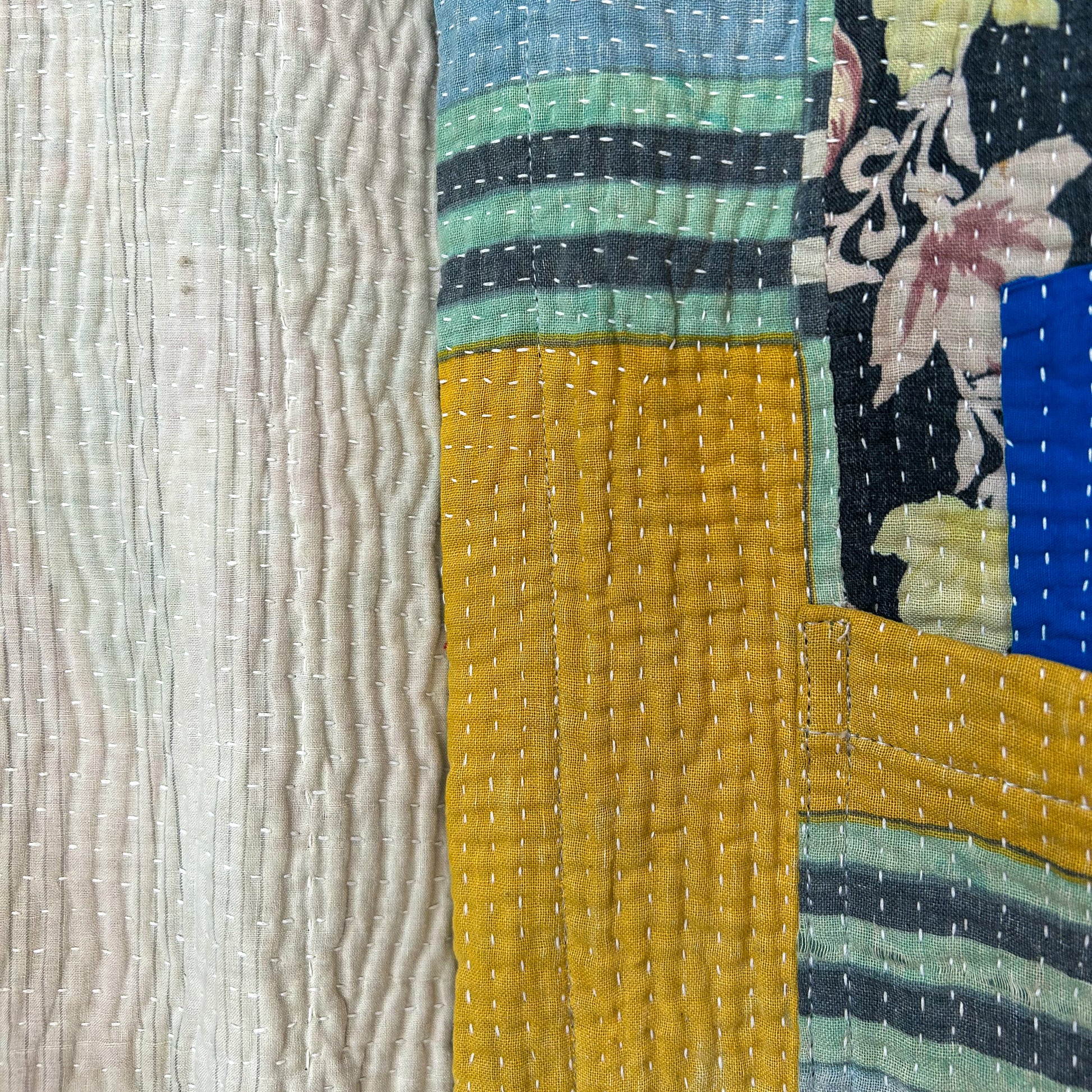 Textile with floral pattern and textured surface. Vintage-kantha-jacket-handmade-unique-39-geometric-colourful-detail
