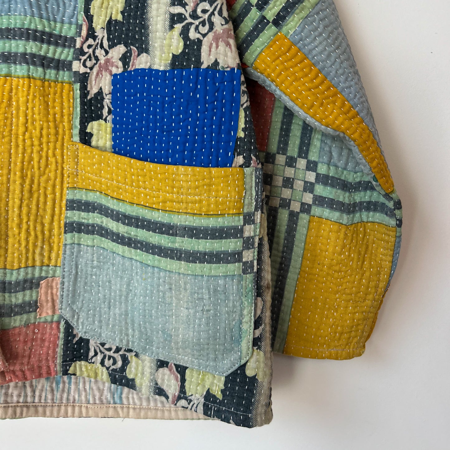 Colorful patchwork kantha with a mix of patterns and colors on a white background. Vintage-kantha-jacket-handmade-unique-39-geometric-colourful-detail