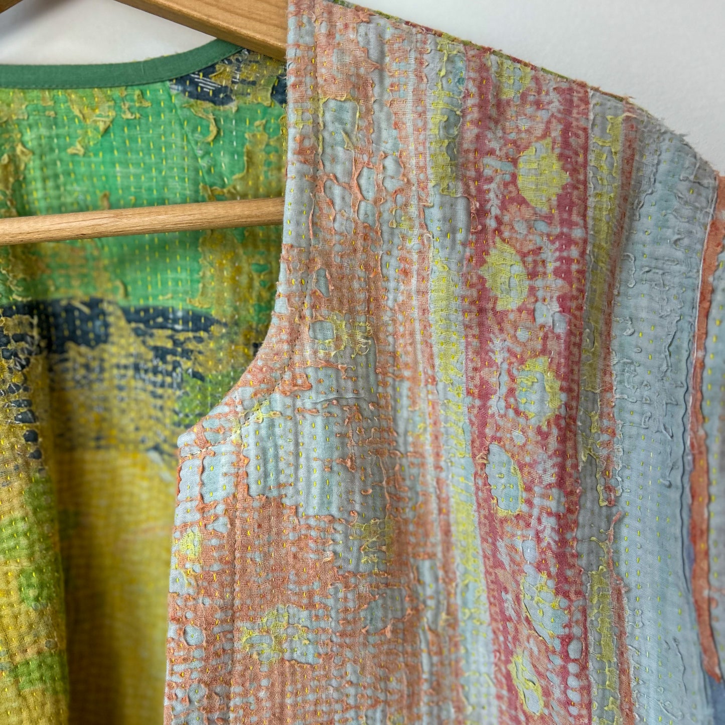 Colorful textured kantha jacket on a wooden hanger against a white background. Vintage-kantha-jacket-handmade-unique-41-textured-collar