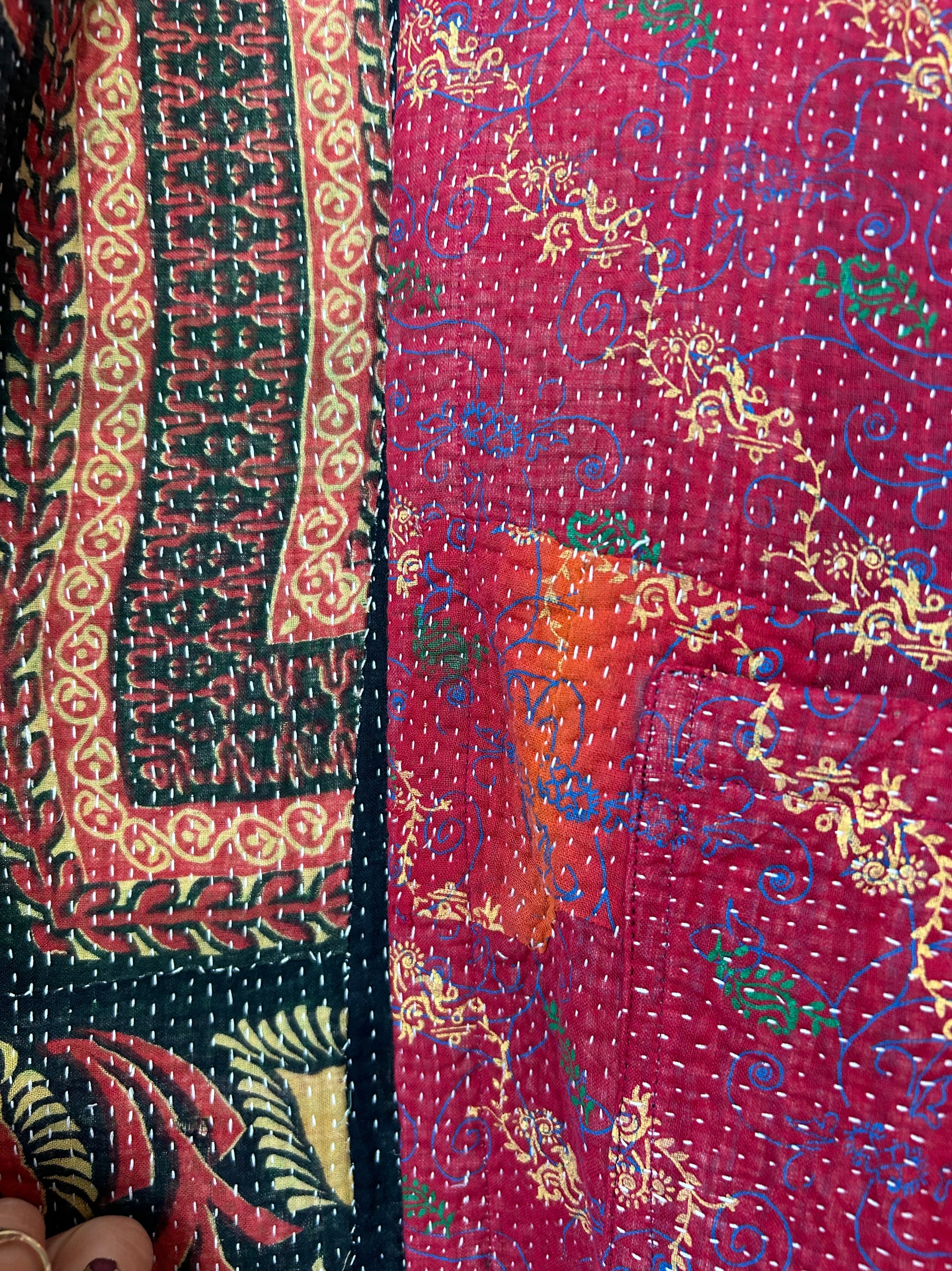 Close-up of a colorful patterned fabric with intricate designs. Vintage-kantha-jacket-handmade-unique-43-detail