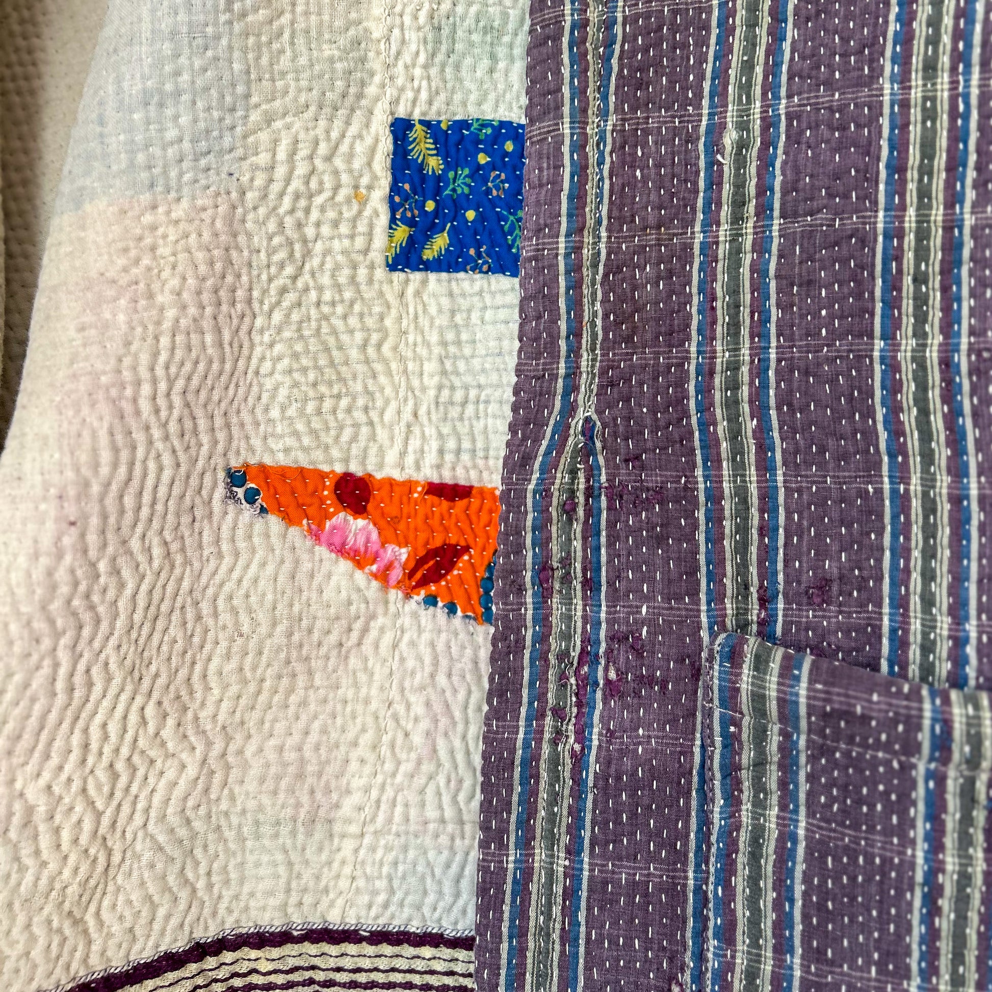 Close-up of a quilt with colorful patchwork design. Vintage-kantha-jacket-handmade-unique-mauve-34-detail