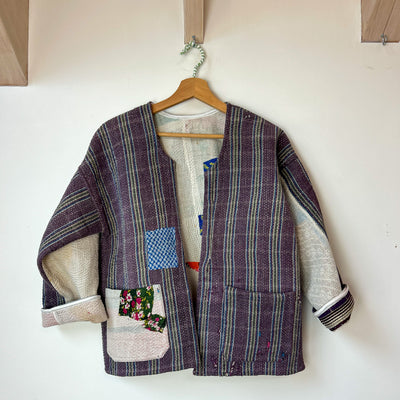 Patchwork kantha jacket on a hanger against a white wall. Vintage-kantha-jacket-handmade-unique-mauve-34