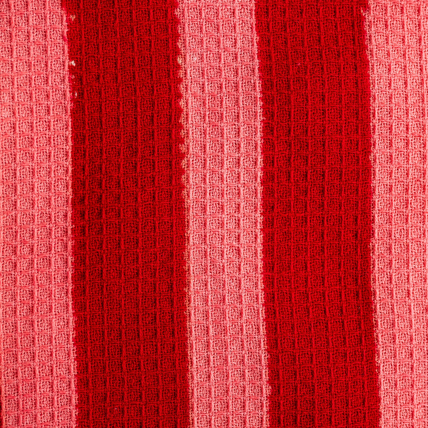 Close-up of red textured fabric with a waffle pattern