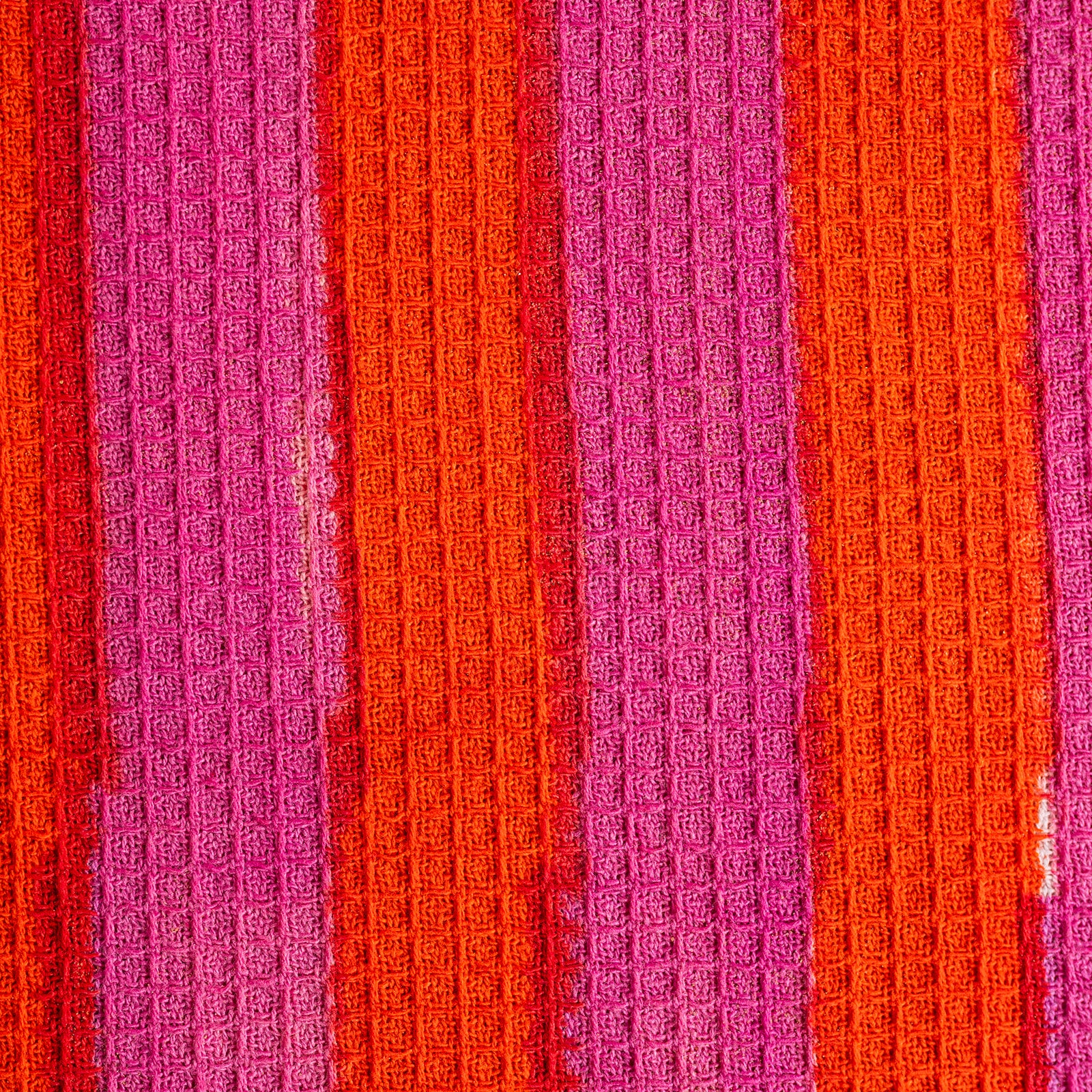 Close-up of textured fabric with alternating pink and orange stripes