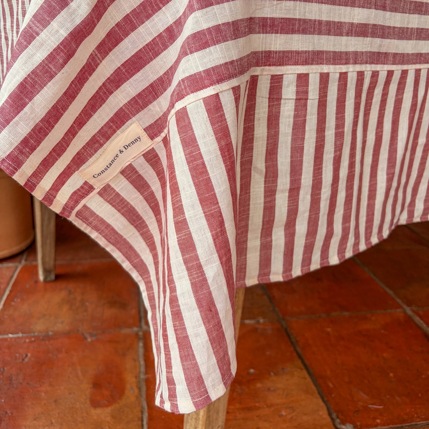 Red and white striped tablecloth on a wooden chair with a visible brand label.