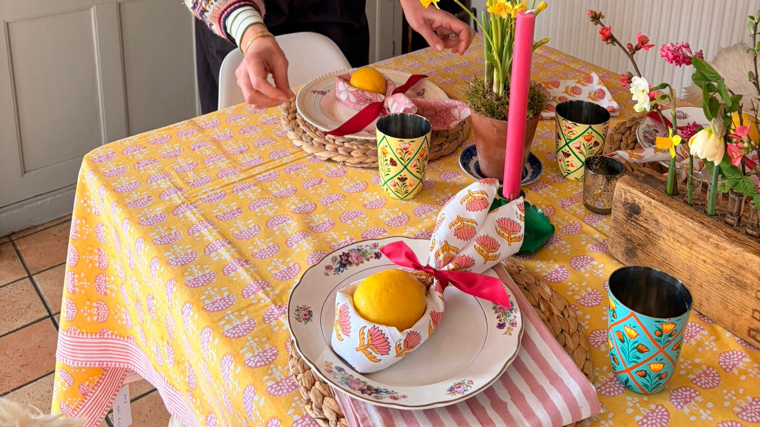 Woman decorating a table with Easter-themed items in a kitchen.
