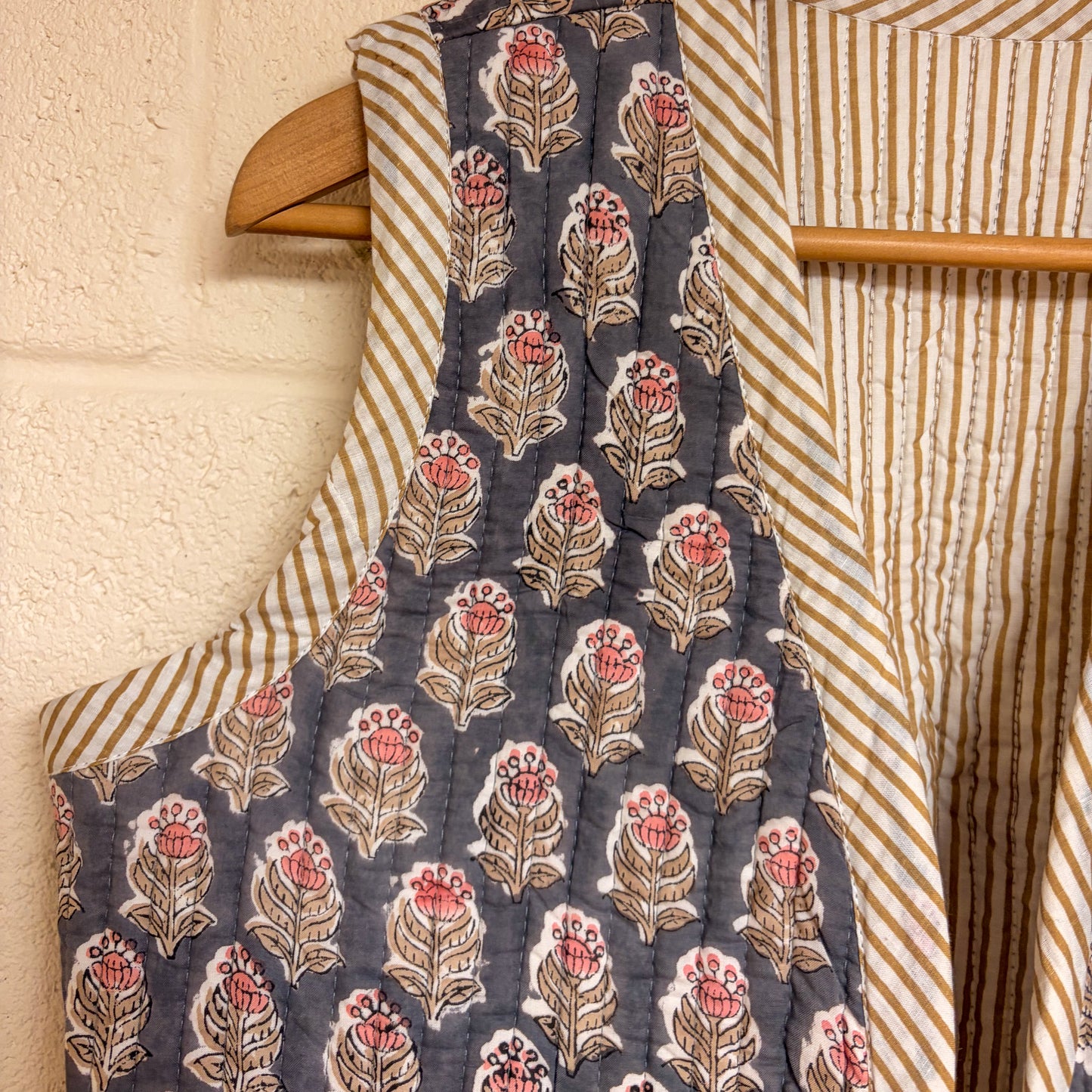 Floral-patterned fabric on a hanger with striped fabric in the background