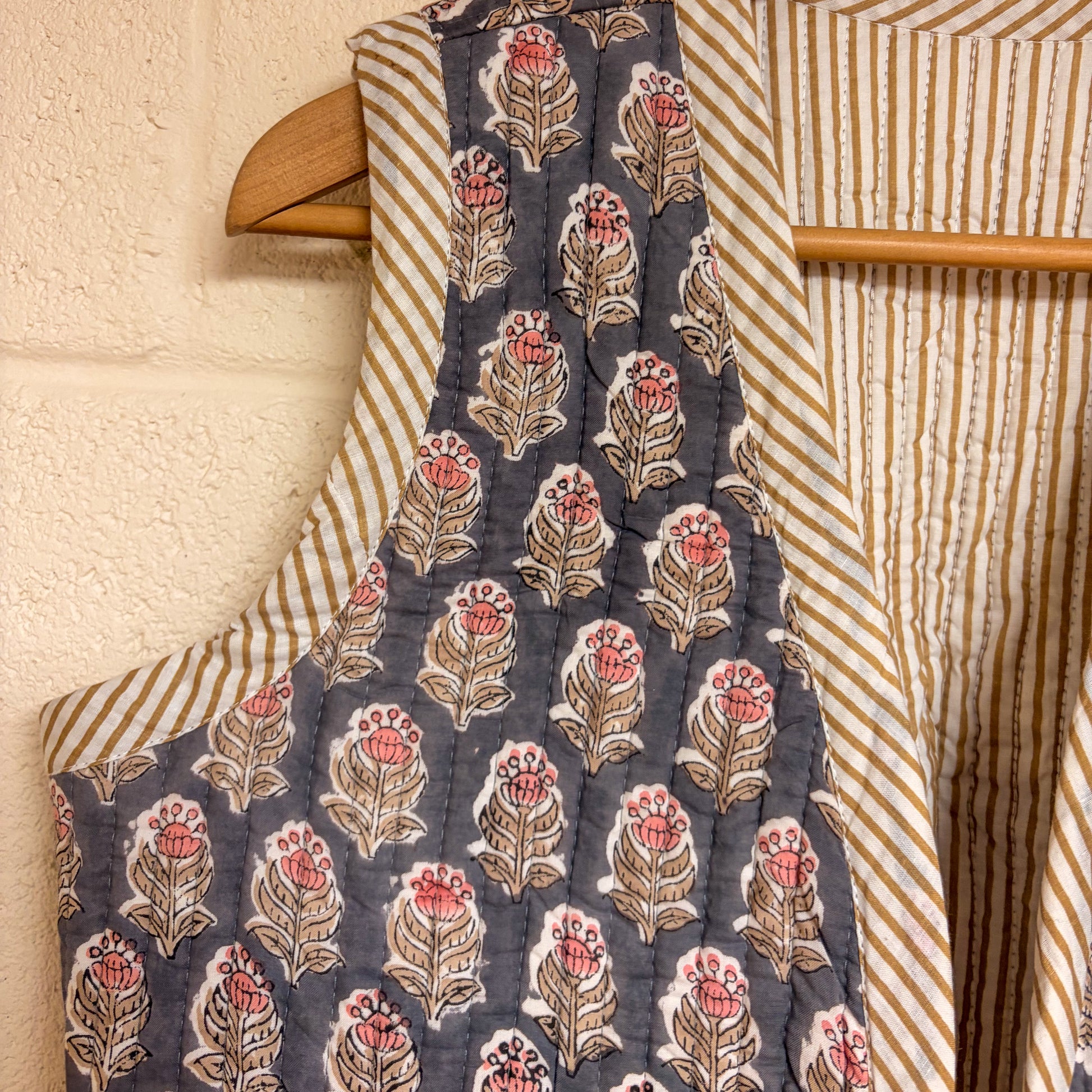 Floral-patterned fabric on a hanger with striped fabric in the background