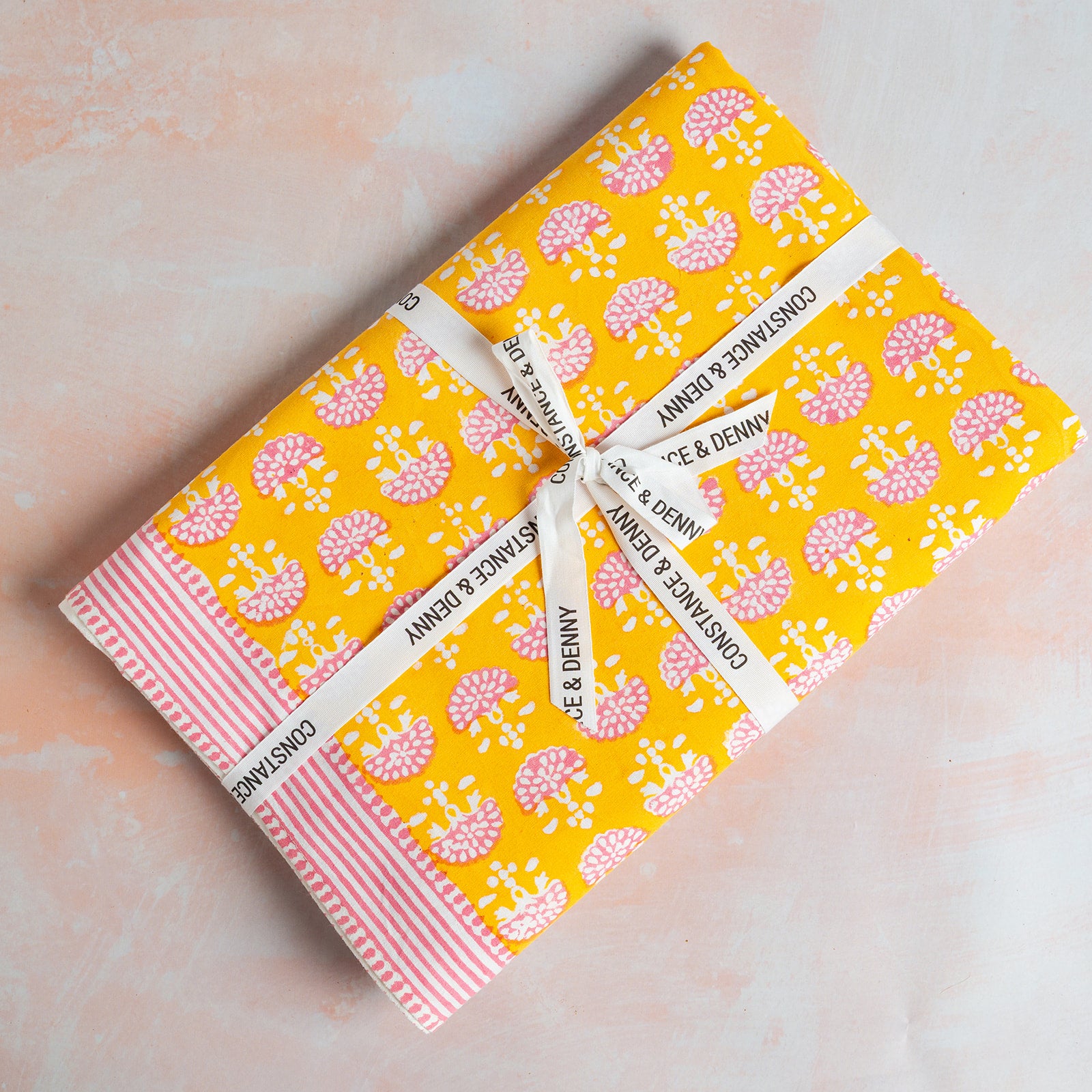 Two notebooks with a yellow and pink floral pattern on a light pink background