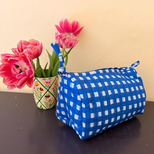 Blue and white checkered cosmetic bag with pink tulips on a beige background