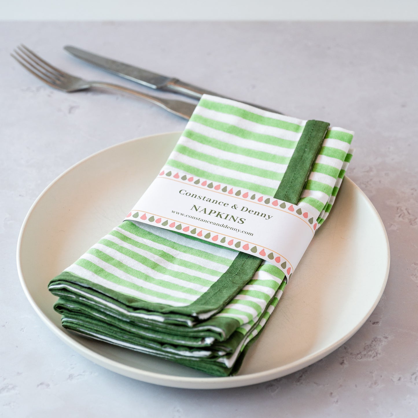GREEN AND WHITE NAPKINS ON PLATE WITH CUTLERY. BLOCK PRINTED