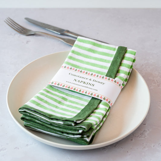 GREEN AND WHITE NAPKINS ON PLATE WITH CUTLERY. BLOCK PRINTED
