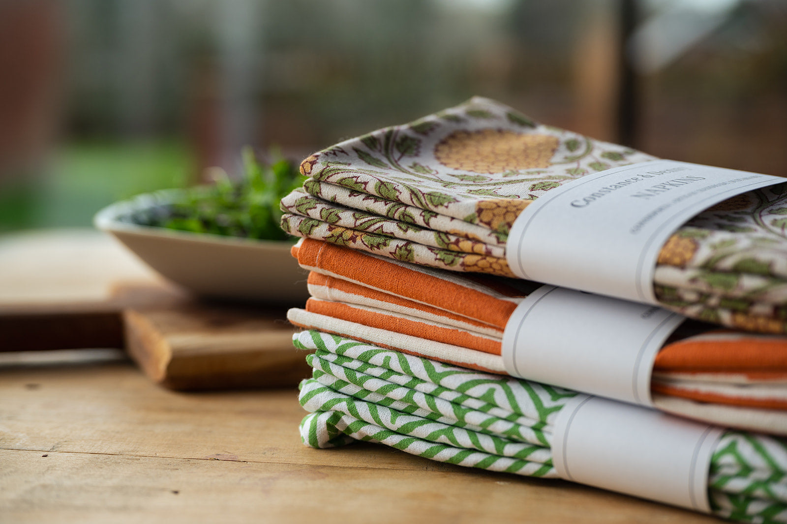 Stack of patterned books on a wooden surface with a blurred background