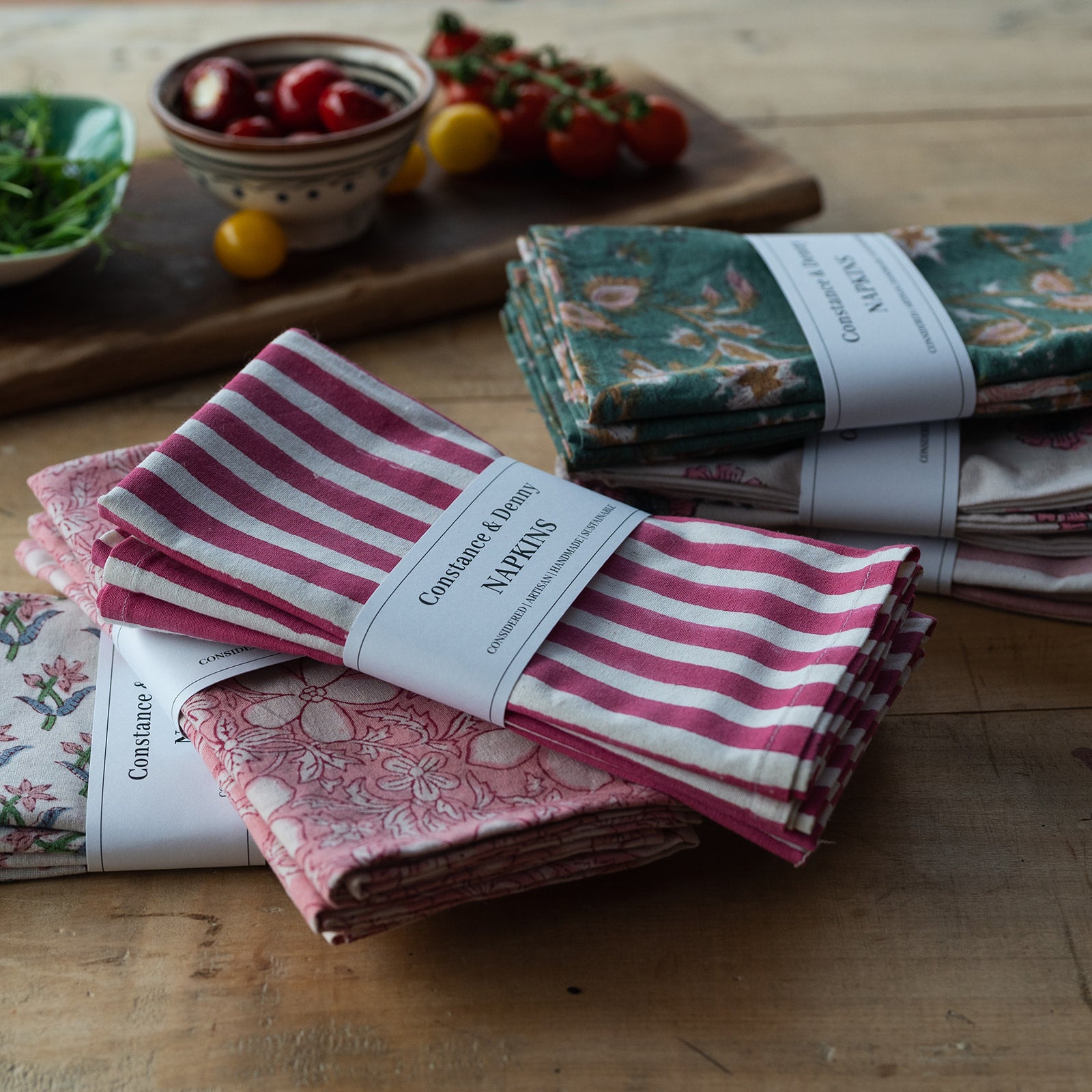 Stack of patterned napkins on a wooden surface with a magazine underneath