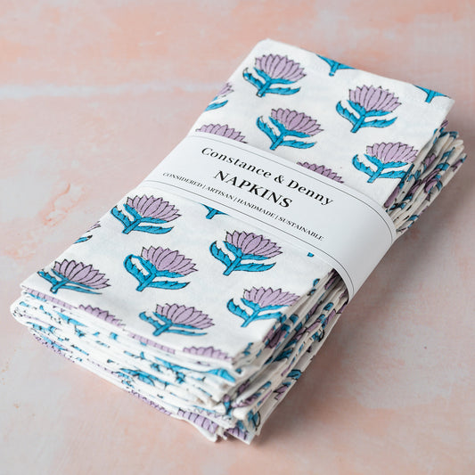 Pack of Constance & Denny napkins with floral design on a light pink background