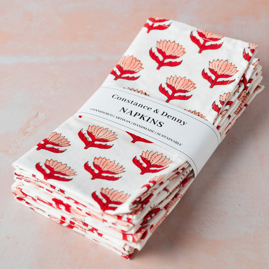 Pack of Constance & Denby napkins with floral design on a light pink background
