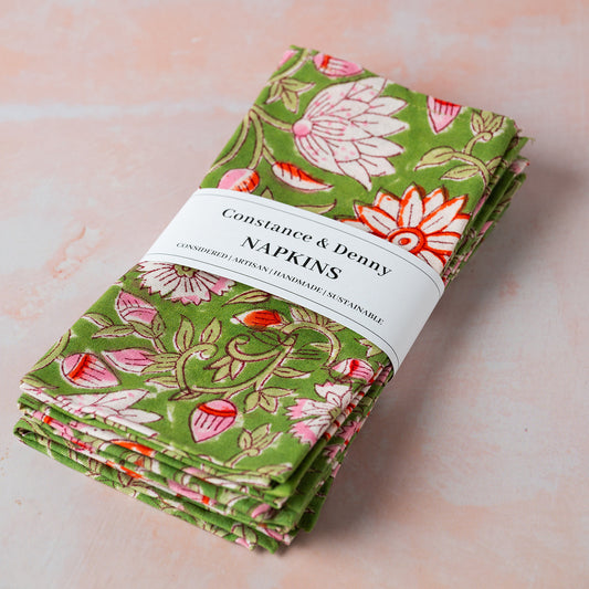 Stack of floral napkins with a visible brand label on a light background