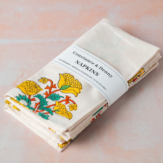 Packaged napkins with floral design and 'Constance & Penny' branding on a soft pink background