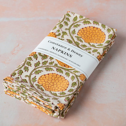 Pack of floral-patterned napkins with 'Constance & Denny' label on a light background
