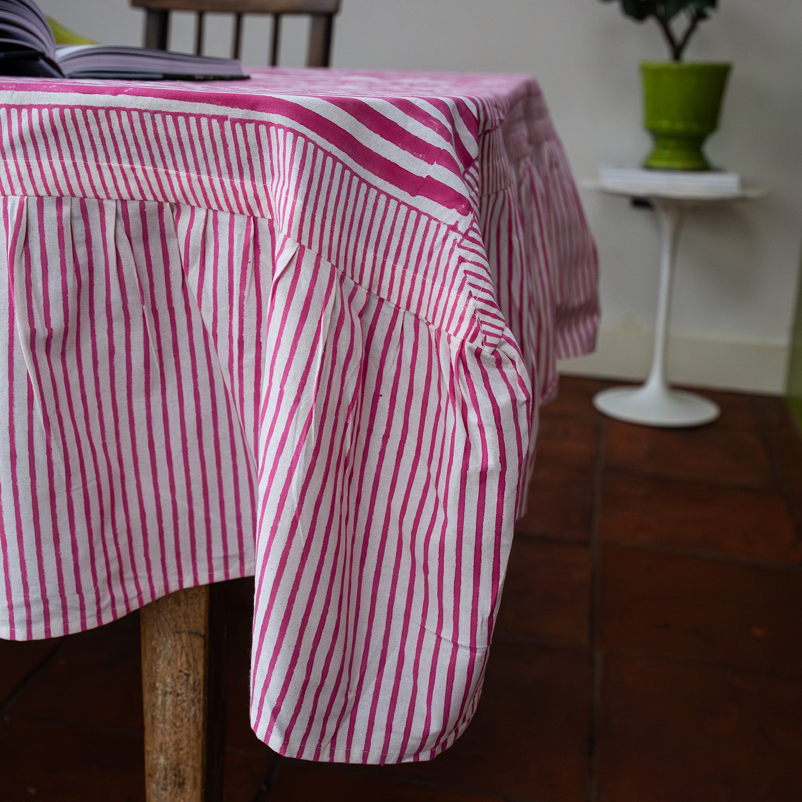 Pink and white striped tablecloth on a wooden table with a blurred background