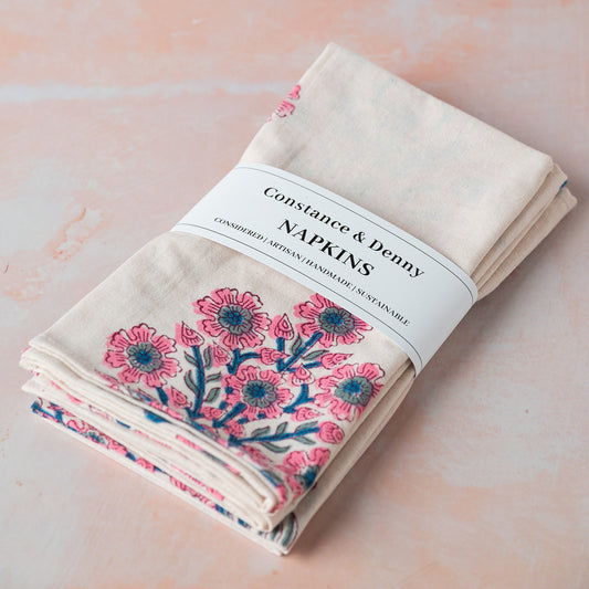Folded floral napkins with 'Constance & Denny' label on a light background