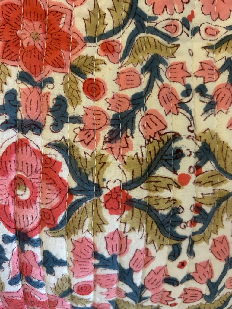 Close-up of floral patterned fabric with pink, green, and blue colors.