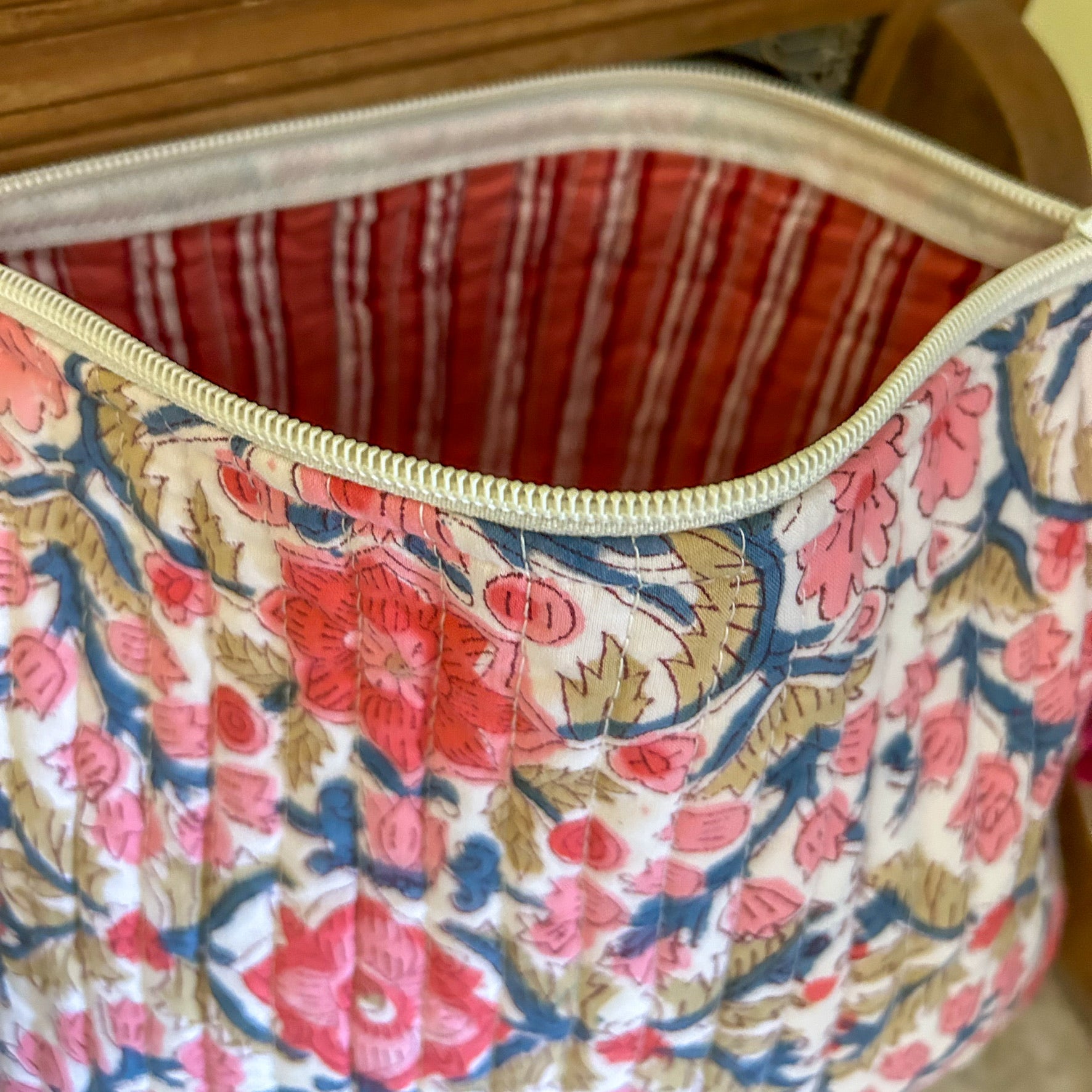 Floral-patterned bag with a zipper, showing the inside lining.